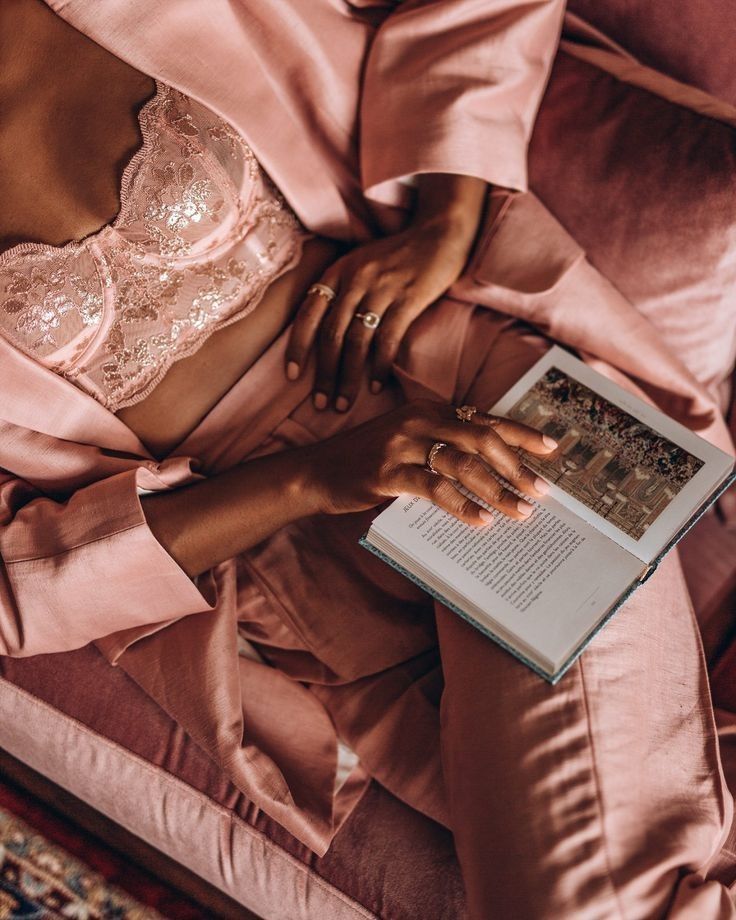 Woman in pink lace lounge set drinking tea in a soft, serene moment