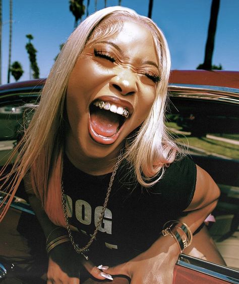 Urban Black woman leaning out a window, eyes closed, wearing a serene expression of freedom and peace