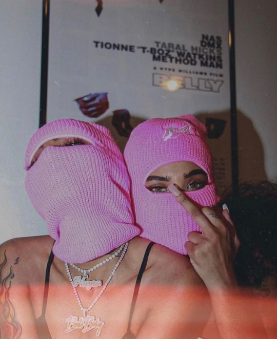Woman of color wearing a pink ski mask, styled in bold urban fashion, expressing fierce individuality and fearless feminine energy